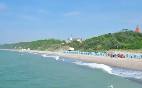 Strand mit Strandkörben und grünen Hügeln. Hier finden Sie Rerik Geheimtipps für einen entspannten Urlaub an der Ostsee.