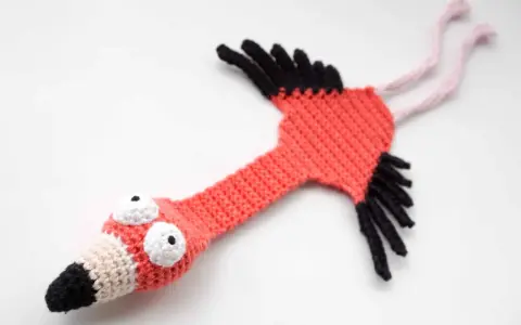 Flamenco amigurumi hecho a mano, con ojos saltones y pico bicolor. ¡Un patrón gratis para crear tu propio flamenco!