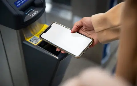 Dłoń zbliża smartfon do czytnika biletów. Szybkie płatności przez Euronet, bez prowizji PKO.