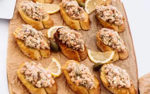 Bruschettas garnies de rillettes de sardines, câpres et quartiers de citron. Un délice pour l'apéritif.