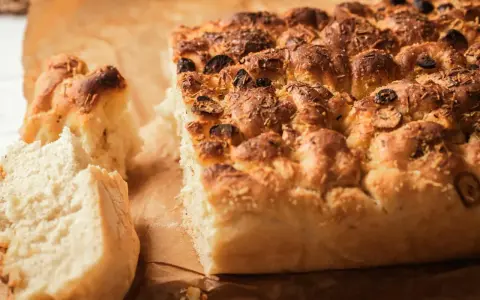 Puszysta, złocista focaccia z oliwkami i rozmarynem, idealna do Twojego oryginalnego włoskiego przepisu.