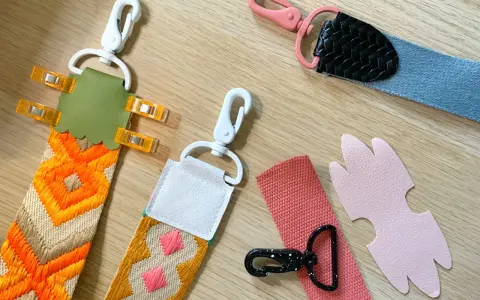 Tuto sangle : plusieurs anses de sacs colorées, avec mousquetons et pièces en cuir, prêtes à être assemblées.