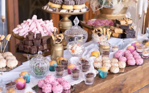 Mesa dulce para una boda: brownies, malvaviscos rosas, donuts, pastelitos y más. Un candy bar casero perfecto.