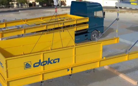 Montaje de una plataforma de descarga obra con vigas amarillas y un camión azul.