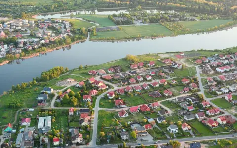 Widok z lotu ptaka na malownicze jezioro Pniewy otoczone zielenią i zabudowaniami.
