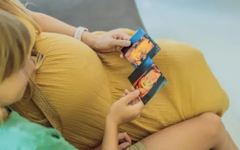 Dziecko na zdjęciach usg 3d, które trzymają mama i starsze rodzeństwo.