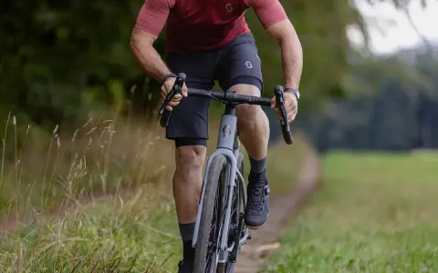 A cyclist rides on a gravel path, showing how many calories 10 minutes of cycling burns.