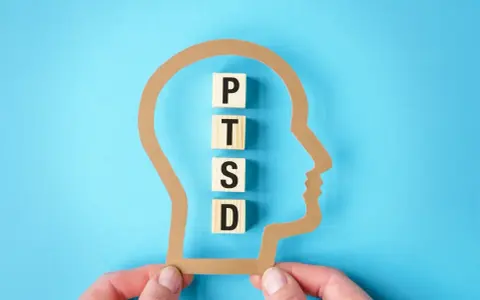Klocki z literami P, T, S, D układają się w napis PTSD wewnątrz sylwetki głowy. Zrozumienie, ptsd co to, jest kluczowe dla pomocy.