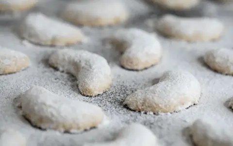 Zarte Vanillekipferl, mit Puderzucker bestäubt, warten darauf, genossen zu werden.