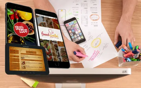 Diseño de apps para restaurantes: teléfonos y tabletas muestran menús y logos. Bocetos y marcadores sugieren planificación.