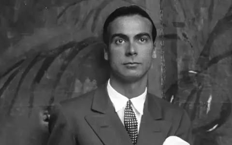 Ritratto di Cristóbal Balenciaga, il cui nome è sinonimo di alta moda. Indossa un abito elegante con cravatta a pois.