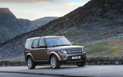 Brązowy Land Rover Discovery 4 na tle górskich krajobrazów. Nawet w tak malowniczym miejscu mogą pojawić się land rover discovery 4 awarie i problemy.