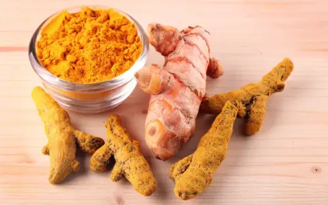Racines de curcuma fraîches et en poudre, symboles des nombreux curcuma bienfait pour la santé.