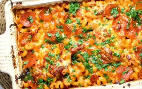 Zapiekanka makaronowa z serem, pepperoni i natką pietruszki w naczyniu żaroodpornym.