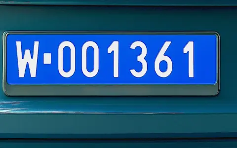 Niebieska tablica rejestracyjna z białymi znakami: W-001361.