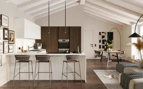 Elegante cucina in mansarda bassa con isola centrale, sgabelli e zona pranzo.