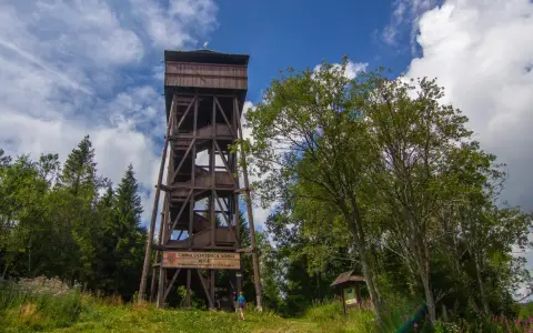 Drewniana wieża widokowa na Magurkach zaprasza do podziwiania panoramy. Wokół bujna zieleń i błękitne niebo.
