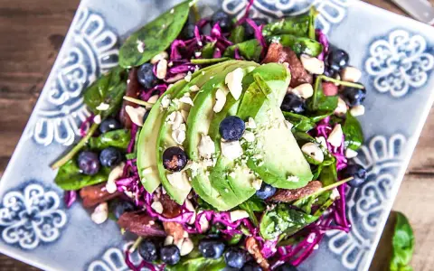 En fräsch sallad med avokado, blåbär och nötter, perfekt som tilltugg till bubbel.