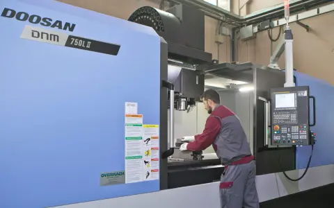 Operaio lavora su centro di lavoro CNC, strumento essenziale per il software progettazione e la produzione di precisione.