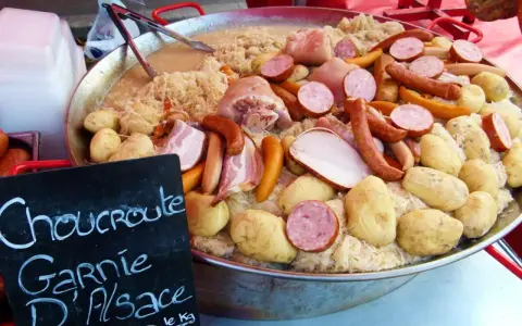 Choucroute garnie d'Alsace, une spécialité alsacienne généreuse avec saucisses, lard, porc et pommes de terre sur choucroute.
