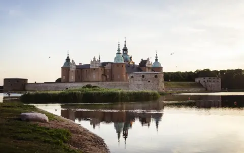 Kalmar Slott, ett populärt utflyktsmål, speglar sig i vattnet en stilla kväll.