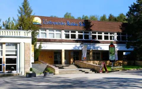 Sanatorium Jagiellonka w Rabce-Zdroju, budynek z napisem "Uzdrowisko Rabka S.A." i dużą butelką solanki.