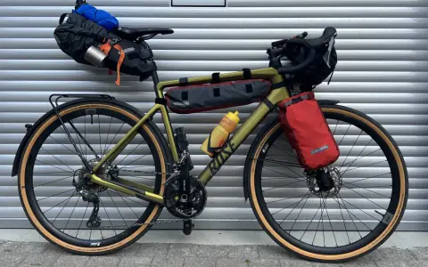 Gravelbike mit Packtaschen für Bikepacking. Das Zelt ist im Satteltaschen-Setup verstaut, bereit für das nächste Abenteuer.