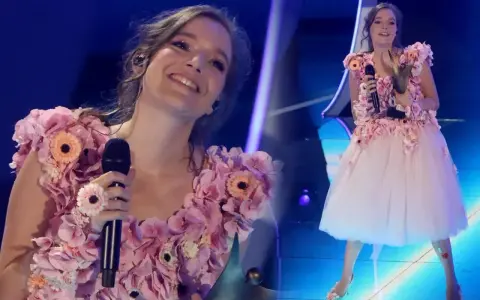 Zuzanna Jurczak, znana jako piosenkarka, w kwiecistej sukni na scenie.