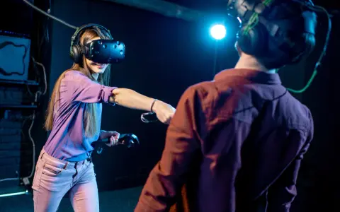 Para grająca w gry na Google VR, zanurzona w wirtualnej rzeczywistości, z kontrolerami w dłoniach.