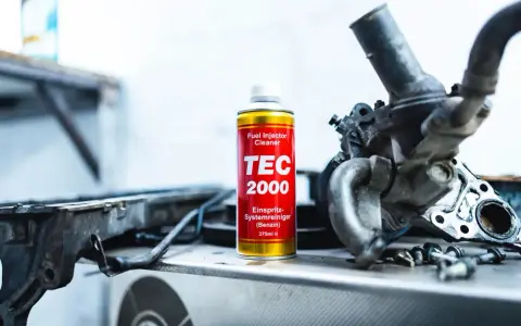 TEC 2000 płukanka do wtryskiwaczy obok rozebranego silnika.