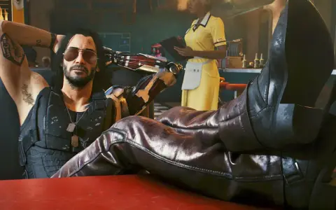 Un hombre con brazo cibernético y tatuajes, con las botas puestas sobre una mesa, como en una guía de Cyberpunk 2077.