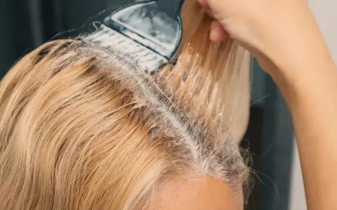 Nakładanie rozjaśniacza na blond włosy, by uzyskać efekt jak naturalnie rozjaśnić włosy.