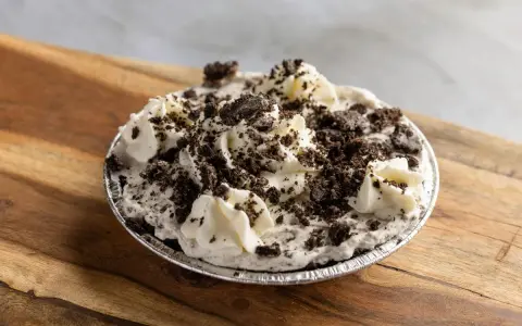 Pyszna masa oreo do tortu, udekorowana bitą śmietaną i pokruszonymi ciasteczkami. Idealna na deser!