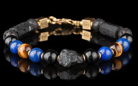 Bransoleta z lapis lazuli i kamienia wulkanicznego, ozdobiona złotymi elementami. Idealna dla osób szukających swojego znaku zodiaku.