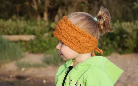 Niña con diadema de lana tejida, ideal para aprender como hacer diademas de lana para niñas.