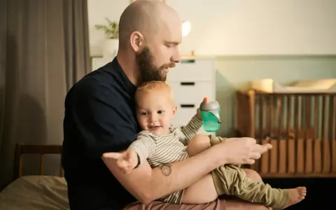 Ojciec z dzieckiem na rękach, czas spędzony razem to najlepszy urlop wychowawczy, lepszy niż urlop wypoczynkowy.