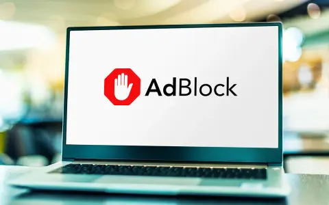Laptop z logo AdBlock. Chcesz wiedzieć, jak wyłączyć adblocka na laptopie?