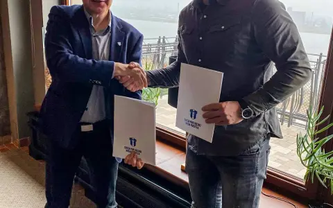Mirsad Terzić i partnerzy podpisują dokumenty. Uściski dłoni i białe teczki z logo klubu.