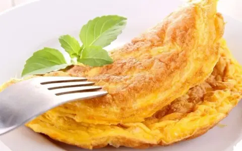 Puszysty omlet z piekarnika, złocisty i lekki, z gałązką bazylii. Idealny na śniadanie.