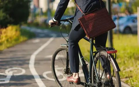 Biznesmen na rowerze, jadący ścieżką rowerową. Zastanawia się, ile promili na rowerze jest dopuszczalne, by bezpiecznie dotrzeć do celu.
