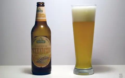 Kustosz piwo pszeniczne, naturalnie mętne, w butelce i szklance z obfitą pianką. Idealne na letnie popołudnie.