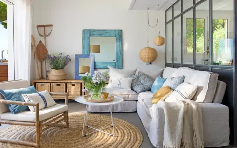 Ideas para decorar casa playa poco presupuesto: sofá blanco, alfombra de yute, cestas de mimbre y detalles marineros.