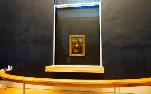 Mona Lisa w muzeum, za pancerną szybą. Słynny obraz Leonarda da Vinci przyciąga tłumy zwiedzających.