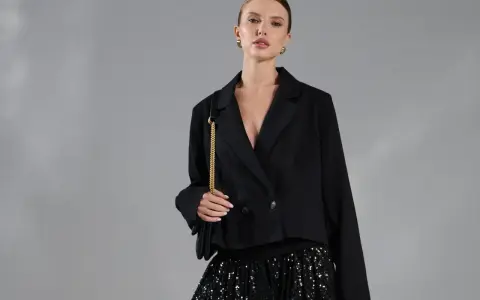 Elegancka kobieta w czarnym żakiecie i błyszczącej spódnicy cekinowej. Stylowe spódnica cekinowa stylizacje na wieczór.