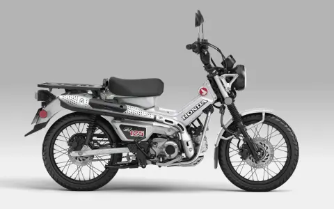 Srebrny motocykl Honda CT 125 z czarnym siedzeniem i bagażnikiem, gotowy na przygodę.