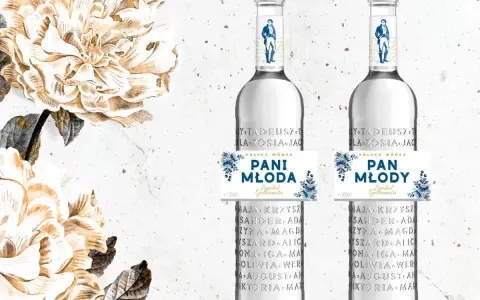 Dwie butelki polskiej wódki "Pan Tadeusz" z etykietami "Pani Młoda" i "Pan Młody", ozdobione kwiatami.