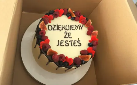 Ozdobiony owocami tort z napisem "Dziękujemy, że jesteś". Wskazówka, jak zrobić napis na torcie.
