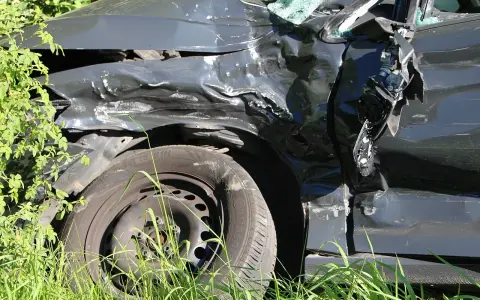 Zniszczony samochód po wypadku, z powyginaną karoserią i pękniętą szybą. Ciekawe, jakie zniżki AC po ilu latach można uzyskać po takiej przygodzie.