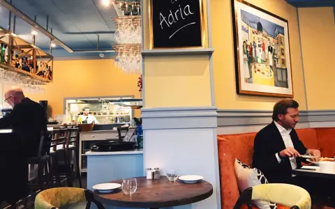 Man äter på Adria ristorante & bar. En tavla med texten "Adria" hänger på väggen.