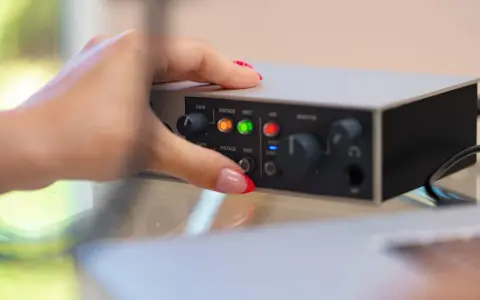 Dłoń z czerwonym lakierem na paznokciach dotyka panelu urządzenia, pokazując jak podłączyć mio smartbox iii.